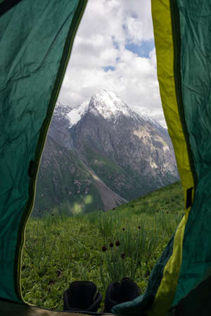 Mountain landscape view in Kyrgyzstan. Rocks, snow and stones in mountain valley view. Mountain panorama. View from tent.の写真素材