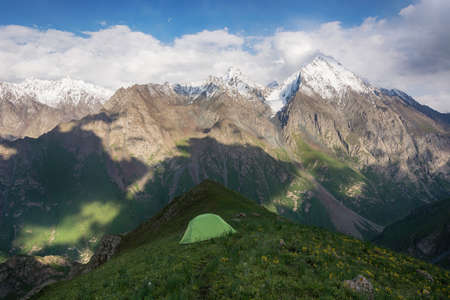 Mountain landscape view in Kyrgyzstan. Rocks, snow and tent in mountain valley view. Mountain panorama.の写真素材