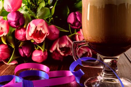 Cup of coffee with heart and colourful tulipsの写真素材