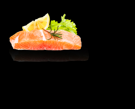 Salmon fillet and herbs isolated on black backgroundの写真素材