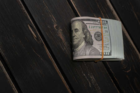 Wad of Dollar banknotes on wooden background with copy space for your text. Cash moneyの写真素材