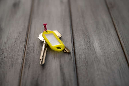 Keys with keychain hanging on an old wooden wall