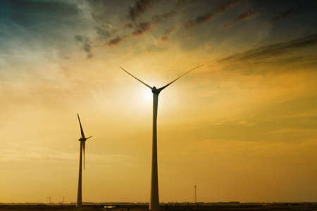 Silhouettes of the wind farms generating clean renewable energy. green concept energy