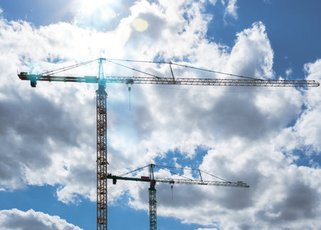 Silhouettes of tower cranes against a dramatic sky. Construction siteの写真素材