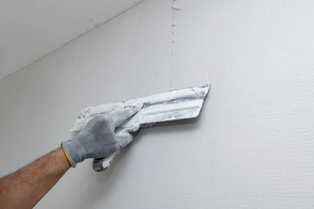 Plasterer applies plaster on the wall during repair and restoration work. Leveling the wall with a spatula.の写真素材