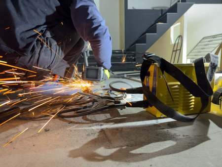 An industrial worker works with metal on an angle grinder. A worker cuts grinds and polishes steel...