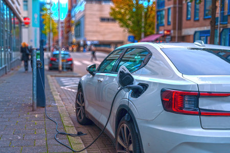 Electromobile in white color charges batteries. Electromobility and ecology.