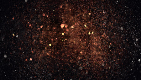 Holiday abstract bokeh on black background. Festive sparkling gold dust. Holiday conceptの写真素材
