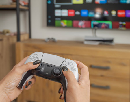 Close-up of woman hands holding a gaming controller, emphasizing modern gaming, entertainment, and...