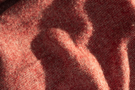 lose-up macro of a red woven blanket with soft fuzzy texture and hem detailâ€”ideal for...