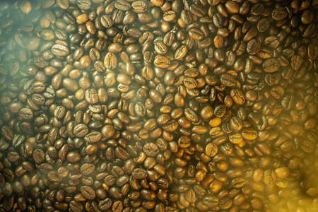 Close-up of roasted coffee beans with soft steam and haze, dramatic warm lighting, rich texture...
