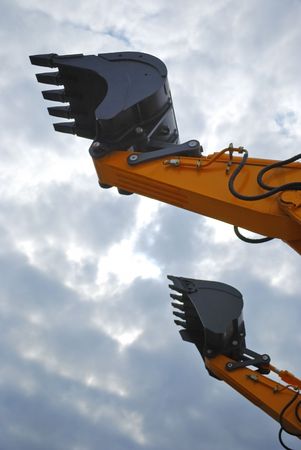 scoop of power-shovel is on cloud sky