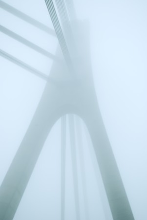 industrial constructions are in fog, details of bridge are in a grey color