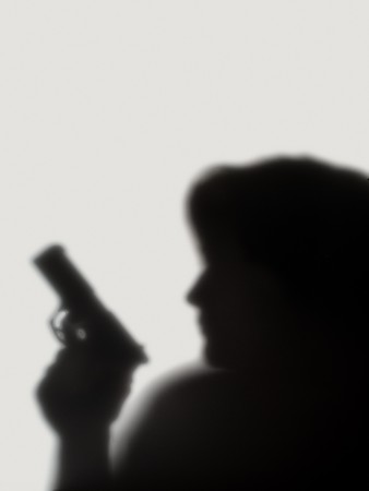 shade of woman  with a pistol on a white backgroundの写真素材