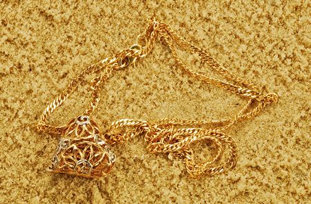 gold chainlets are on yellow loose sand