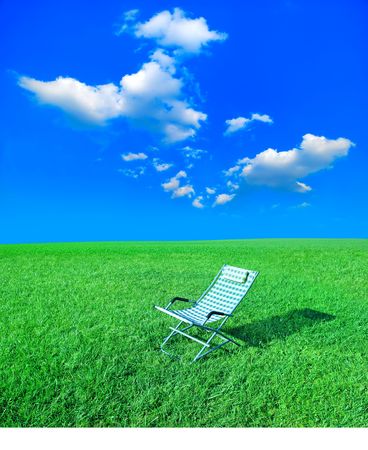 simple chaise lounge on the green grassの写真素材