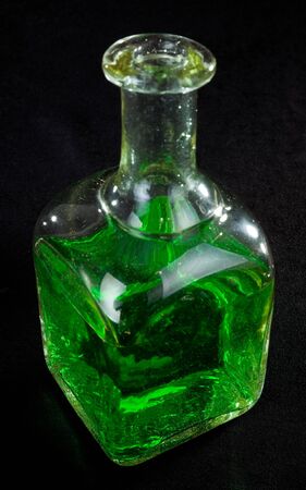 bottle  of green liquid on black backgroundの写真素材