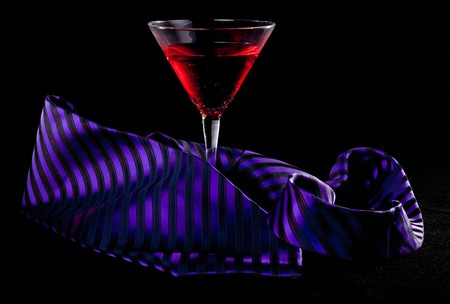 glass of cocktails and necktie on blackの写真素材