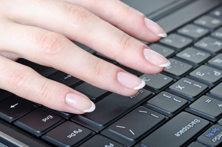 women's fingers over the keyboard laptop