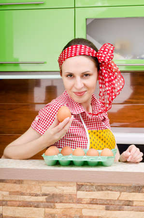 housewife chooses eggs on the background of kitchen interiorsの写真素材