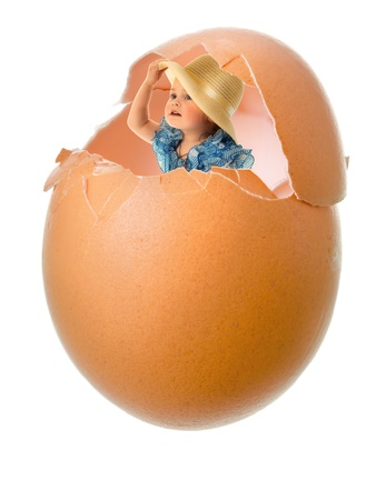 little girl in blue dress in broken egg shell closeup on white backgroundの写真素材