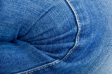 Women's knee in jeans with folds closeupの写真素材