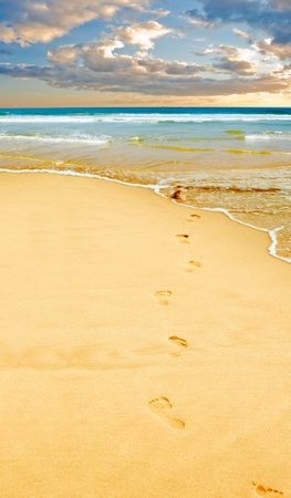 Footprints in the yellow sand, sea in distance の写真素材