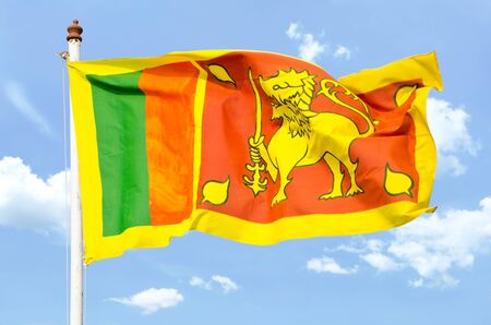 national flag of Sri Lanka. yellow cloth. On the left side - of equal stripes of green and orange, arranged vertically. In the right - yellow lion with a sword in a dark red rectangle. In the corners of the rectangle are four images of sheets of wood bodhの写真素材