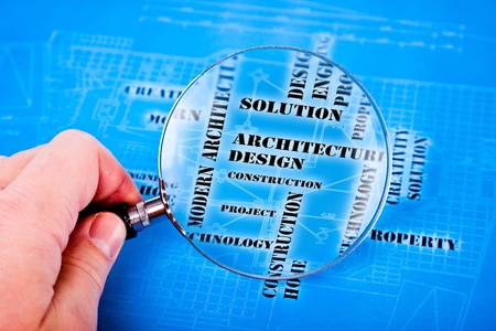 human hand with a magnifying glass on the art architectural backgroundの写真素材