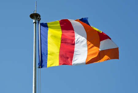 symbolic flag of Buddhism against the cloudless sky.の写真素材