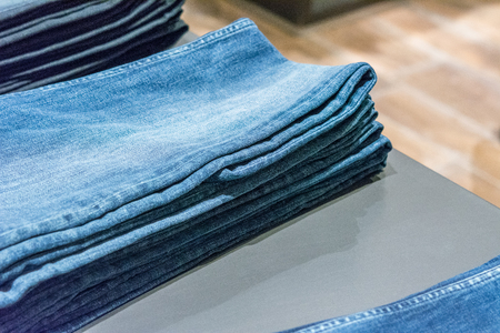 Jeans stacked on a wooden backgroundの写真素材