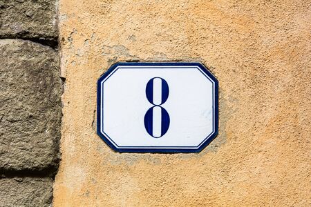 house number eight , eighth ( 8 ) on a roughcast wall