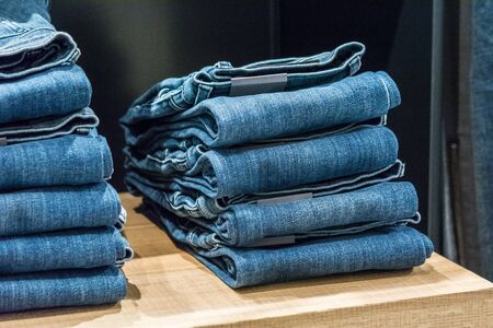 Jeans stacked on a wooden backgroundの写真素材