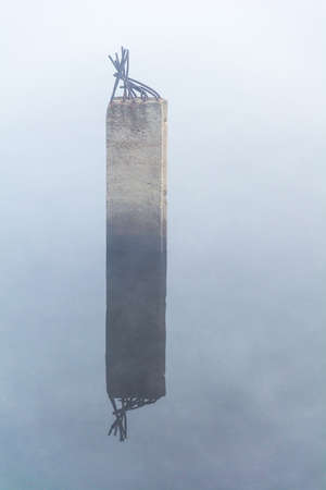 A picturesque concrete pillar sticks out of the water