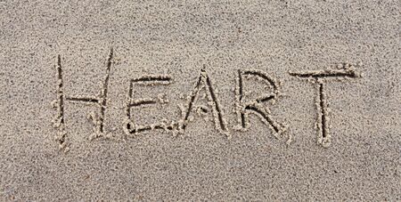 Inscription "Heart" on wet sand.の写真素材