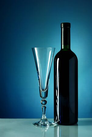 wine bottle and wine glass on a blue backgroundの写真素材