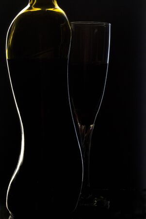 A bottle of wine and a glass on a black backgroundの写真素材
