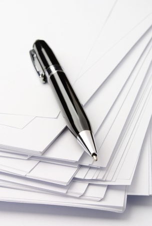 black ballpoint pen and sheets of white paperの写真素材