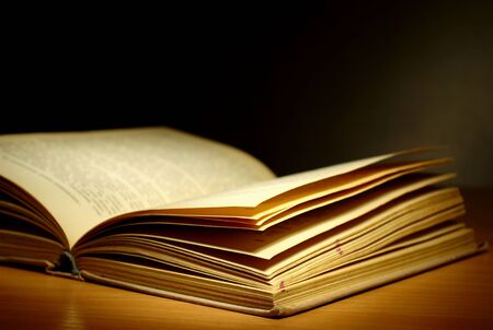 old book on a dark background and light beamの写真素材