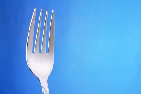 table forks with four teeth on a blue gradient backgroundの写真素材