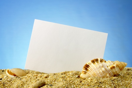 Card on a sea theme, a paper on sand and a dark blue backgroundの写真素材