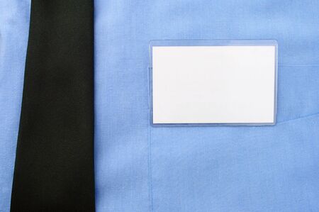 The badge is attached to a pocket of a blue shirt