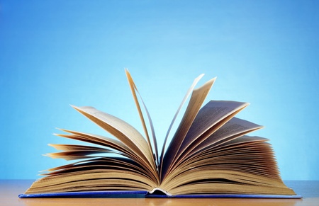 open book on a table and a blue backgroundの写真素材