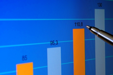 Pointing at financial analysis graph on computer monitor with penの写真素材