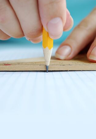 Women's hands are working with a pencil and ruler