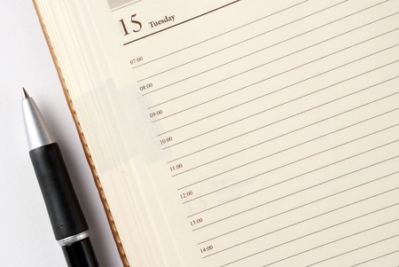 open notebook on the 15th day of the month and pens on the tableの写真素材