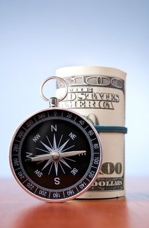 American dollars and compass on a blue gradient backgroundの写真素材