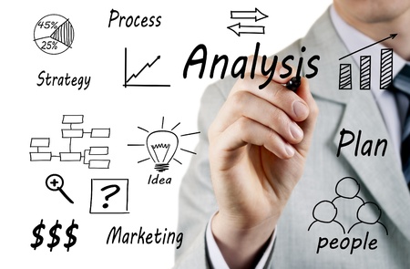 man in a business suit writing on a transparent screen during a presentationの写真素材