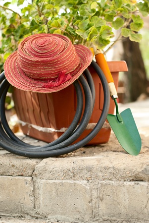 flowers in a pot, garden shovel and garden hoseの写真素材