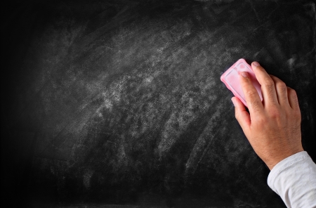 Hand with eraser erases the chalkboardの写真素材